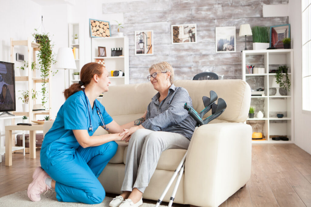 joyful old lady sitting couch nursing home holding health taker arm 1